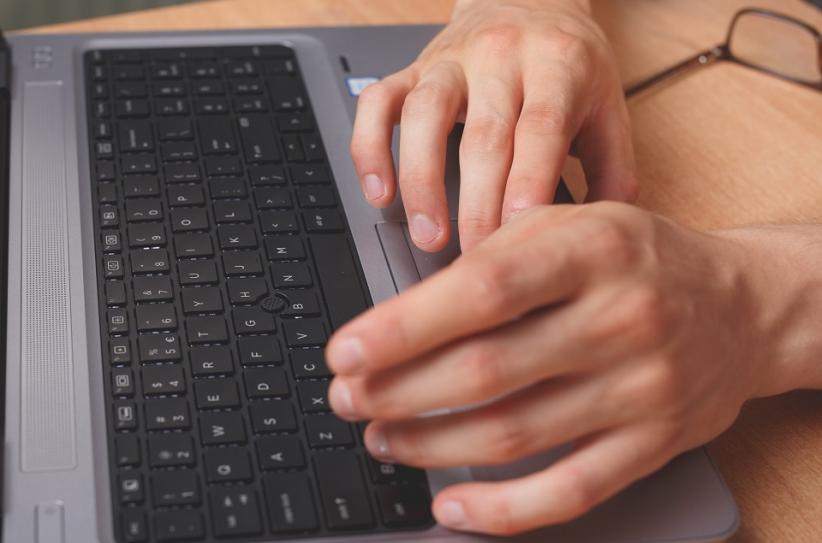 The photo shows hands on the keyboard