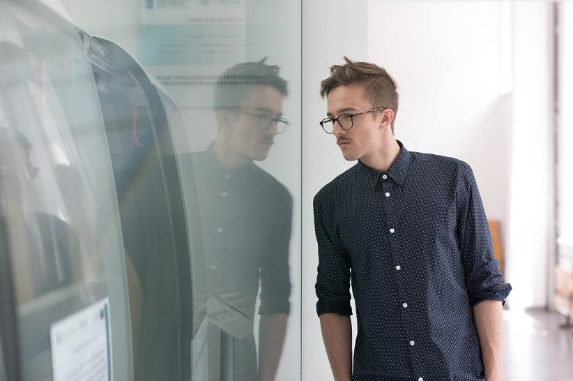 The picture shows a man watching an innovative machine.